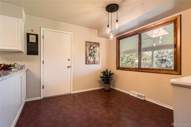 10247 W Arkansas Ave, Lakewood, CO 80232 - unfurnished dining area featuring baseboards and dark flooring