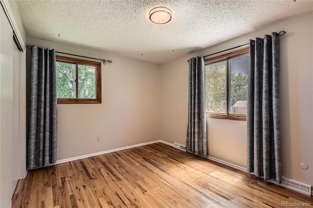10247 W Arkansas Ave, Lakewood, CO 80232 - empty room with wood finished floors, a textured ceiling, and baseboards
