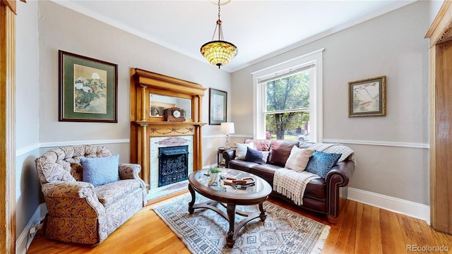 living area featuring a fireplace, wood finished floors, and baseboards