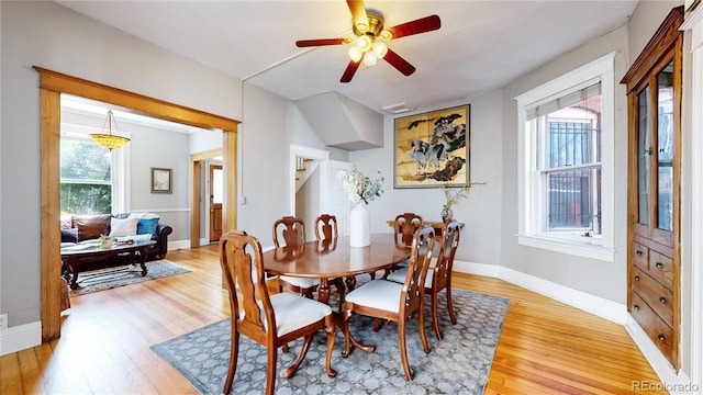 dining area with light wood-type flooring, a wealth of natural light, and baseboards