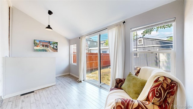 doorway featuring lofted ceiling, baseboards, and wood finished floors