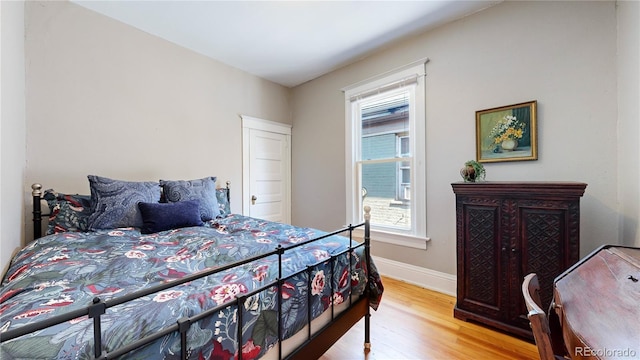 bedroom featuring baseboards and wood finished floors