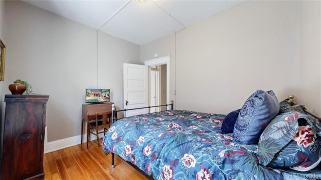 bedroom with baseboards and wood finished floors