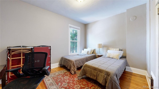 bedroom with wood finished floors and baseboards