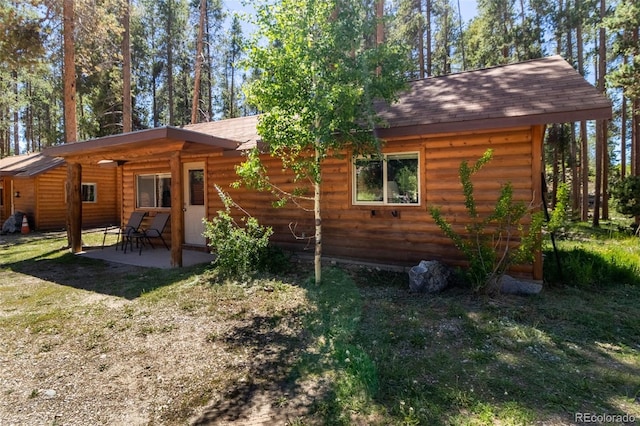 rear view of property with a yard and a patio area