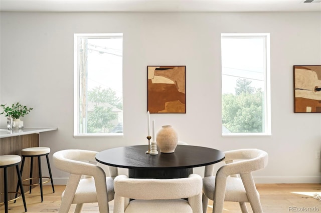 dining space featuring light wood-type flooring and a wealth of natural light