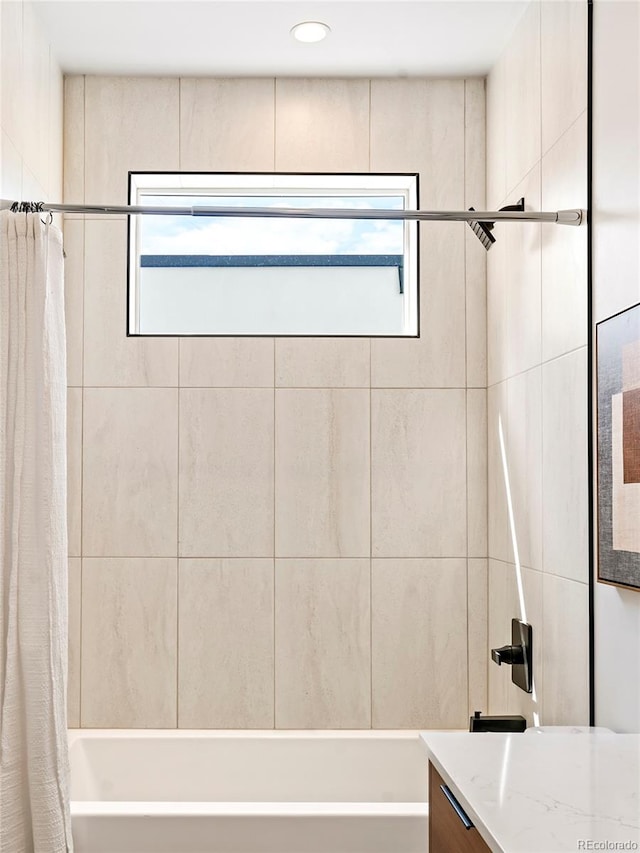 bathroom featuring shower / bath combo with shower curtain, plenty of natural light, and vanity