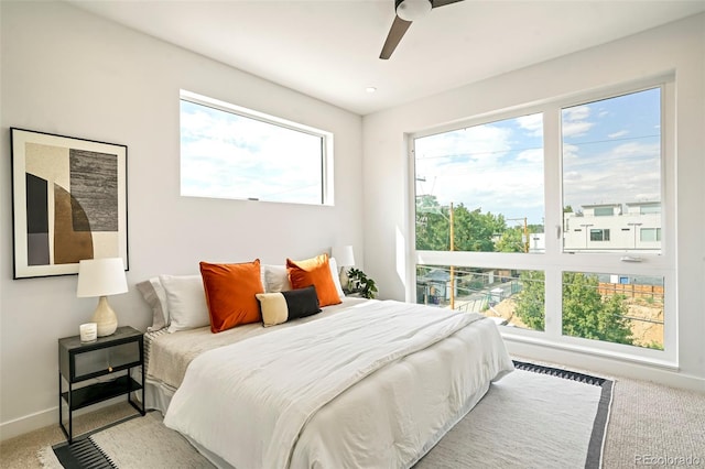 bedroom with ceiling fan, carpet floors, and multiple windows