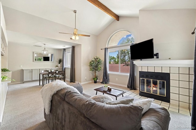 living area featuring light colored carpet, a tile fireplace, beamed ceiling, a ceiling fan, and high vaulted ceiling