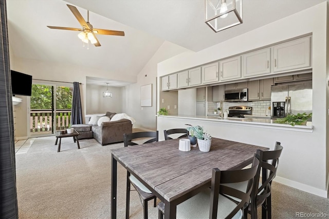 dining area with light colored carpet, lofted ceiling, ceiling fan, and baseboards