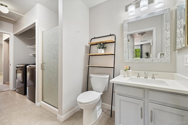 full bathroom featuring independent washer and dryer, a shower stall, toilet, vanity, and baseboards