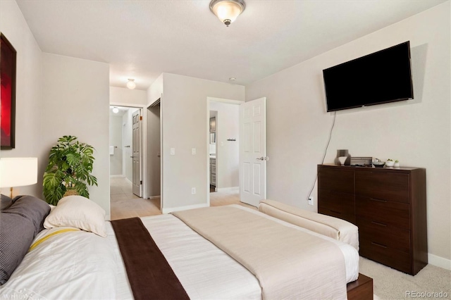 bedroom with baseboards and light carpet