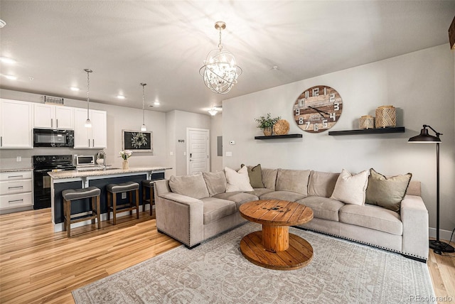 15274 W 64th Ln Unit 206, Arvada, CO 80007 - living room with recessed lighting, an inviting chandelier, light wood finished floors, and visible vents