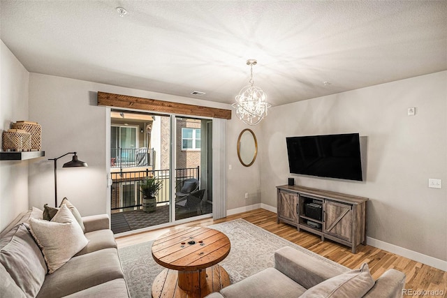 15274 W 64th Ln Unit 206, Arvada, CO 80007 - living area with baseboards, an inviting chandelier, wood finished floors, and visible vents
