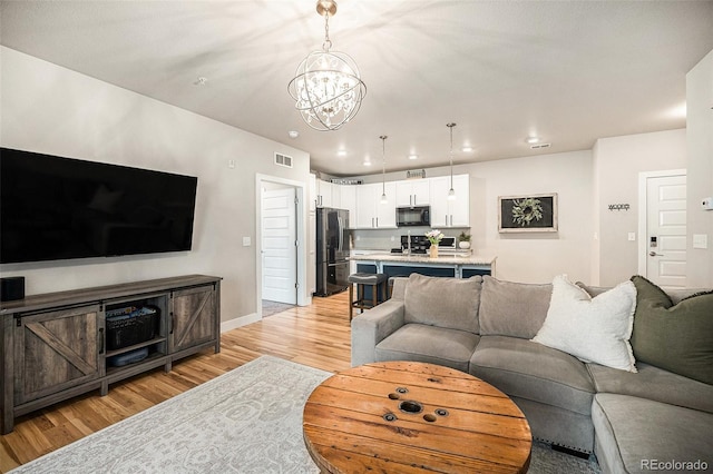 15274 W 64th Ln Unit 206, Arvada, CO 80007 - living area with visible vents, light wood-style floors, baseboards, recessed lighting, and a notable chandelier