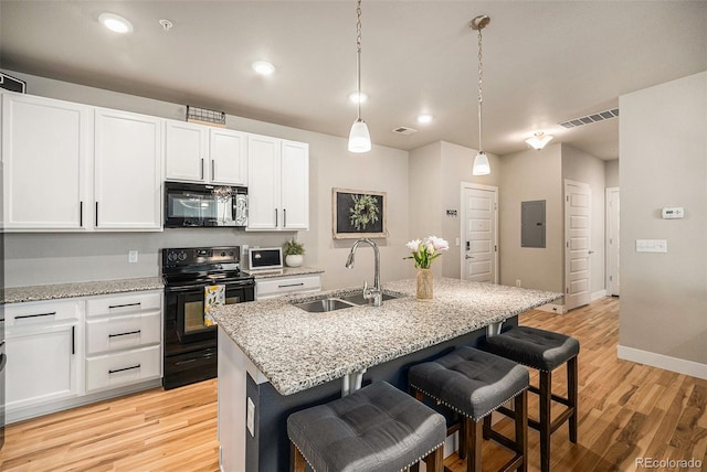 15274 W 64th Ln Unit 206, Arvada, CO 80007 - kitchen featuring a kitchen bar, visible vents, a sink, black range with electric cooktop, and white cabinetry