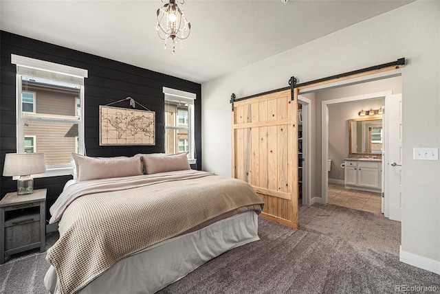 15274 W 64th Ln Unit 206, Arvada, CO 80007 - bedroom with carpet floors, baseboards, ensuite bath, and a barn door