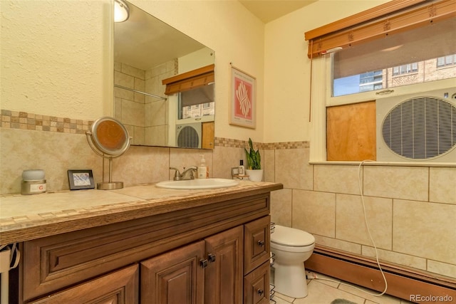 bathroom featuring tile patterned flooring, vanity, tile walls, and toilet