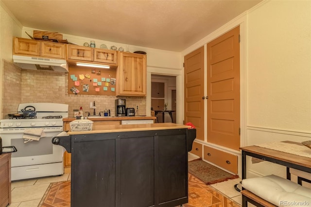 kitchen with backsplash, crown molding, light tile patterned floors, light brown cabinetry, and white range with gas stovetop