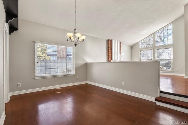 unfurnished room featuring vaulted ceiling, a chandelier, and dark hardwood / wood-style flooring