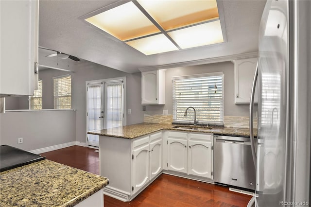 kitchen featuring white cabinetry, appliances with stainless steel finishes, and kitchen peninsula