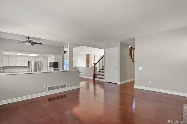 living room featuring ceiling fan and dark hardwood / wood-style flooring