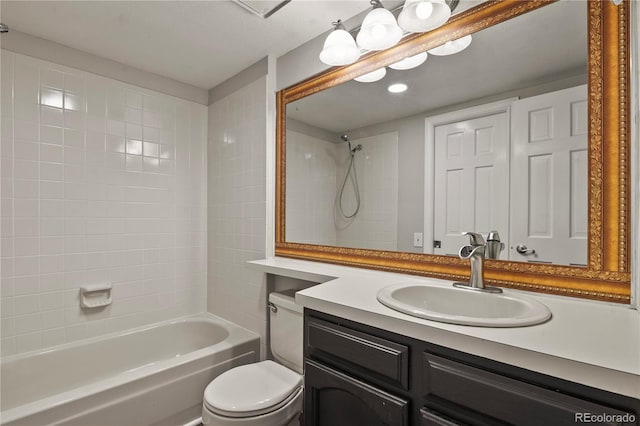 full bathroom featuring tiled shower / bath, vanity, and toilet