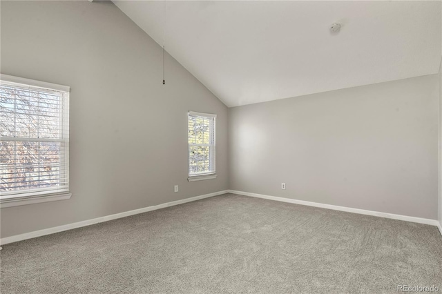 carpeted spare room with high vaulted ceiling