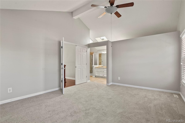 unfurnished bedroom with ensuite bathroom, high vaulted ceiling, ceiling fan, light carpet, and beam ceiling