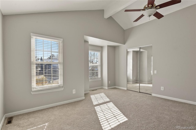 unfurnished bedroom with ceiling fan, a closet, lofted ceiling with beams, and light carpet