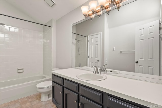 full bathroom with vanity, lofted ceiling, tiled shower / bath, and toilet