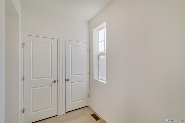 hallway with light hardwood / wood-style floors