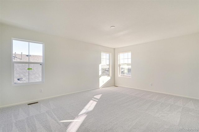 carpeted empty room with a wealth of natural light