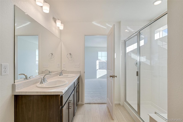 bathroom with plenty of natural light, an enclosed shower, wood-type flooring, and vanity