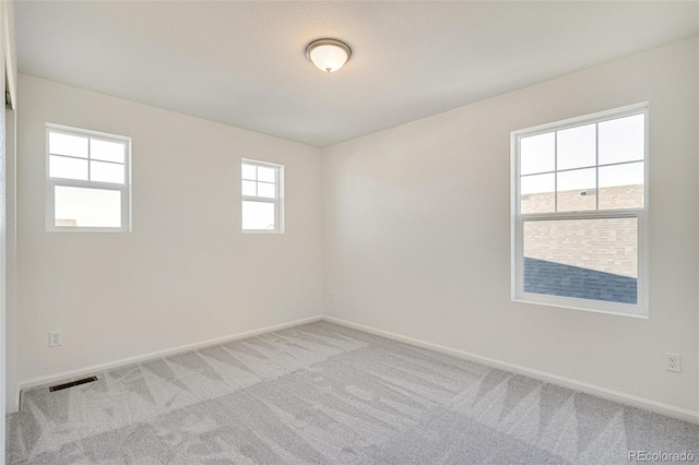 carpeted empty room featuring a wealth of natural light