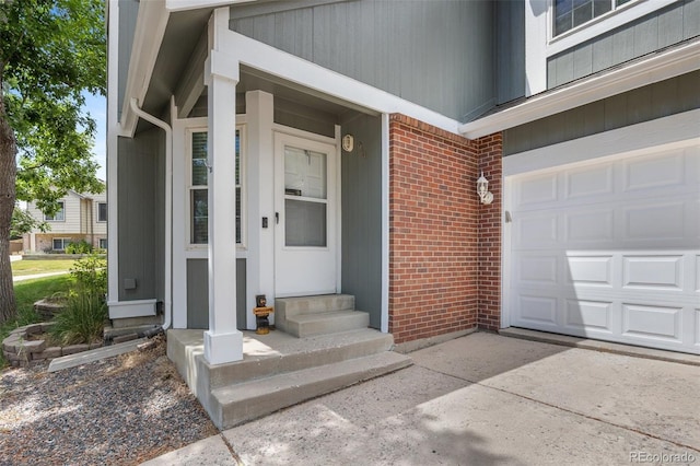 944 E Lily Ct, Highlands Ranch, CO 80126 - doorway to property featuring brick siding, an attached garage, and driveway