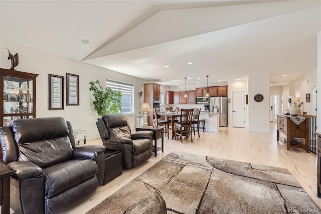 living room featuring light hardwood / wood-style floors and vaulted ceiling