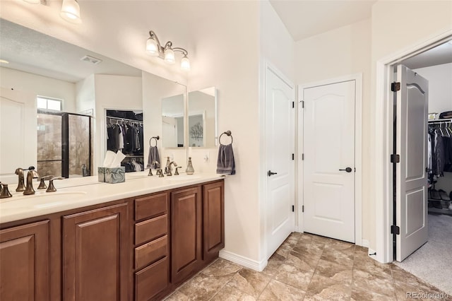 bathroom with a shower with door and vanity