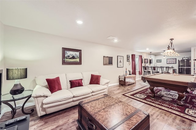 living room with pool table, wood-type flooring, and bar area