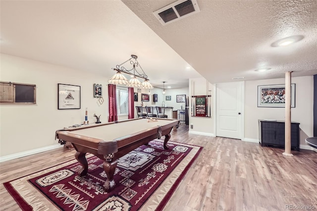 playroom featuring bar, light hardwood / wood-style floors, billiards, and a textured ceiling