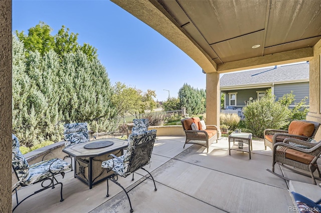 view of patio with an outdoor living space with a fire pit