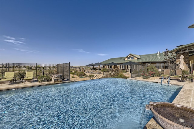 view of pool with a patio and pool water feature