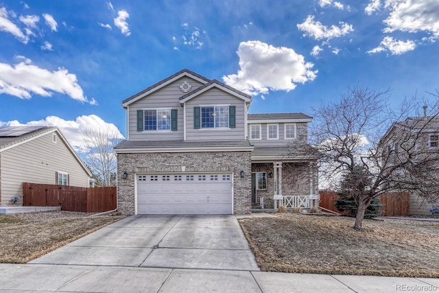 traditional home with a garage, concrete driveway, brick siding, and fence