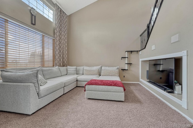 living area featuring high vaulted ceiling, carpet, and baseboards