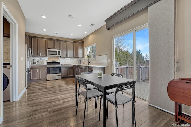 dining space with baseboards, visible vents, dark wood-style floors, washer / clothes dryer, and recessed lighting