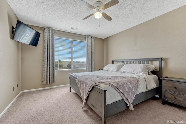 carpeted bedroom featuring a textured ceiling, a ceiling fan, visible vents, and baseboards