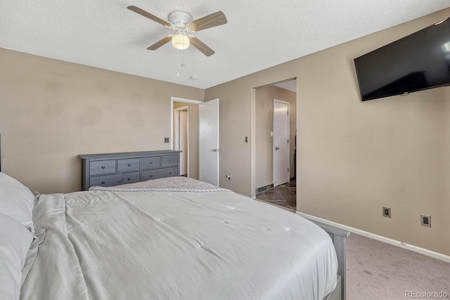 bedroom with a textured ceiling, carpet, a ceiling fan, and baseboards