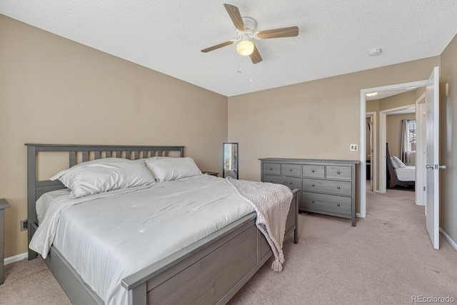 bedroom with light carpet, ceiling fan, a textured ceiling, and baseboards