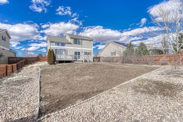 back of house with a fenced backyard and a deck