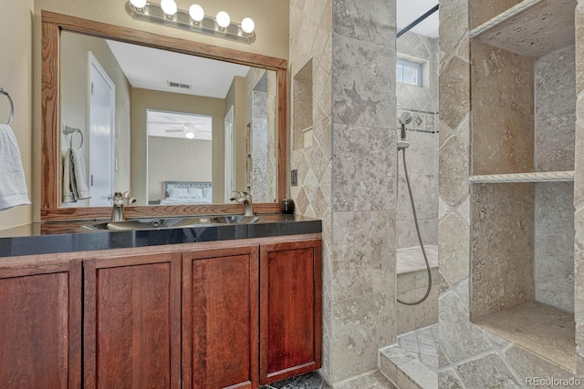 ensuite bathroom with double vanity, visible vents, a ceiling fan, ensuite bath, and walk in shower